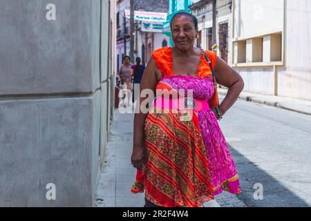 Femme cubaine en robe colorée se dresse dans la rue, Camagüey, Cuba Banque D'Images