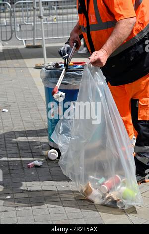 Employé du conseil dans des vêtements haute visibilité ramassant les déchets jetés dans la rue et les ensachant après un événement public (marathon de Bristol) Banque D'Images