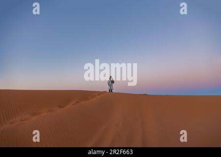 Berber se tient sur une dune dans le désert d'Erg Chebbi au Sahara, au Maroc, tôt le matin Banque D'Images