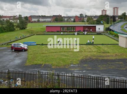 Boules en jeu dans l'enceinte urbaine devant le pavillon rouge du parc de quilles Balornock à Glasgow, en Écosse, au Royaume-Uni Banque D'Images