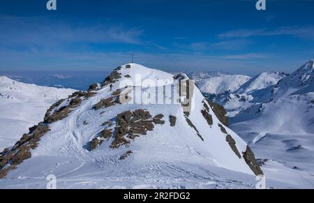 Les amateurs de ski dans les montagnes du Kitzbüheler Alpen sur la montée au sommet du Tristkopf au soleil Banque D'Images