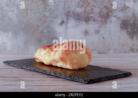 Feuilletage feuilletée de crème pâtissière sur un tableau noir sur une table en bois Banque D'Images
