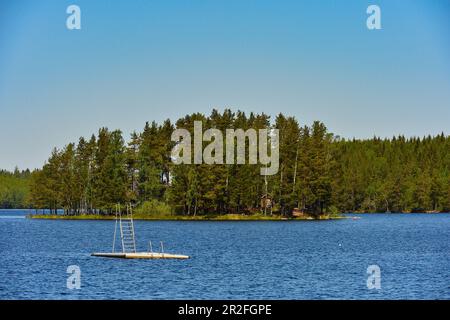 Une petite plate-forme de baignade dans un lac avec une île entourée de forêt, province d'Örebro, Suède Banque D'Images
