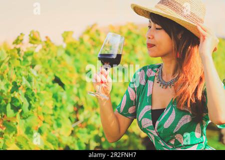 Bonne femme asiatique boit du vin rouge, concept de célébration Banque D'Images