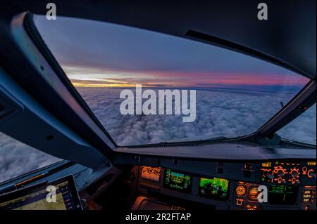 Vue hors du cockpit d'un Airbus A320 au lever du soleil Banque D'Images