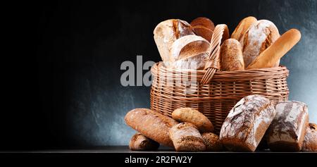 Panier en osier avec assortiment de produits de boulangerie, dont des pains et des petits pains Banque D'Images