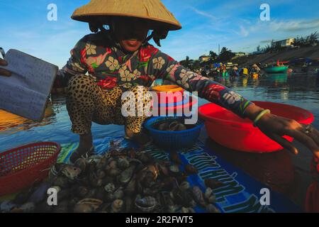 MUI ne - Vietnam - 22 janvier 2019 : le vendeur local collecte des poissons et des shelles dans le célèbre village de pêcheurs de Mui ne, Vietnam Banque D'Images