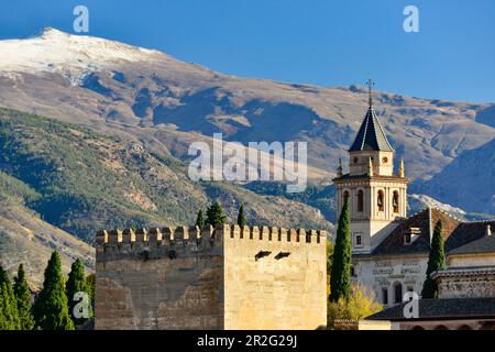 Vue sur une ancienne tour de défense et une église en face de la Sierra Nevada, Grenade, Andalousie, Espagne Banque D'Images