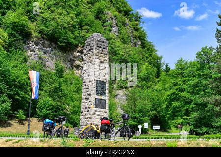 Vélos de voyage avec remorques pour chiens sur le bord de la route devant un monument, près de Klanjec, Croatie Banque D'Images