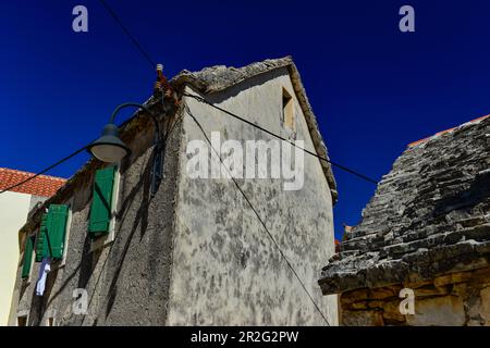 Très ancienne maison avec un toit en pierre en face d'un ciel bleu profond, Primosten, Dalmatie, Croatie Banque D'Images