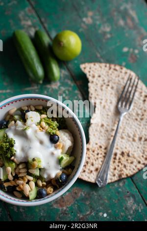 Salade au brocoli, chou-fleur, concombre, bleuets et pignons et sauce au yogourt au citron vert Banque D'Images