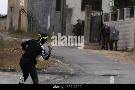 Kufr Qadoom, Naplouse. 19th mai 2023. Un manifestant palestinien utilise un coup de feu pour projeter une pierre sur les soldats israéliens lors d'affrontements à la suite d'une protestation contre l'expansion des colonies juives dans le village de Kufr Qadoom, en Cisjordanie, près de Naplouse, sur 19 mai 2023. Crédit: Nidal Eshtayeh/Xinhua/Alamy Live News Banque D'Images