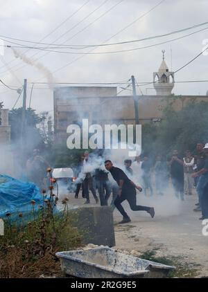 Kufr Qadoom, Naplouse. 19th mai 2023. Un manifestant palestinien renvoie une cartouche de gaz lacrymogène tirée par un soldat israélien lors d'affrontements à la suite d'une protestation contre l'expansion des colonies juives dans le village de Kufr Qadoom, en Cisjordanie, près de Naplouse, sur 19 mai 2023. Crédit: Nidal Eshtayeh/Xinhua/Alamy Live News Banque D'Images