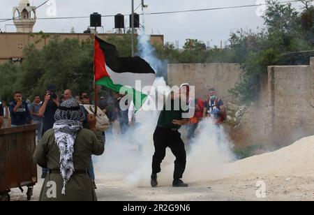 Kufr Qadoom, Naplouse. 19th mai 2023. Un manifestant palestinien renvoie une cartouche de gaz lacrymogène tirée par un soldat israélien lors d'affrontements à la suite d'une protestation contre l'expansion des colonies juives dans le village de Kufr Qadoom, en Cisjordanie, près de Naplouse, sur 19 mai 2023. Crédit: Nidal Eshtayeh/Xinhua/Alamy Live News Banque D'Images