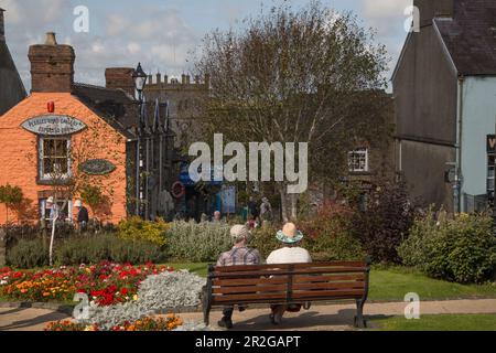 Deux personnes assises sur un banc devant Fern Cottage, Saint Davids, pays de Galles Banque D'Images