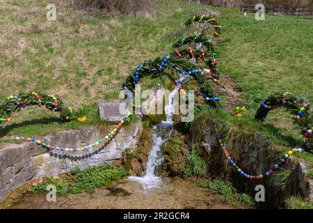 Fontaine de Pâques décorée d'œufs de Pâques colorés, Brunnen am Gries à Egloffstein en Suisse franconienne, Bavière, Allemagne Banque D'Images