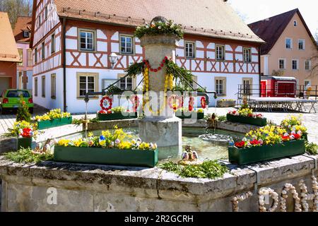 Fontaine de Pâques décorée avec des œufs de Pâques colorés en face de l'hôtel de ville sur la place du marché à Markt Heiligenstadt en Suisse franconienne, B Banque D'Images