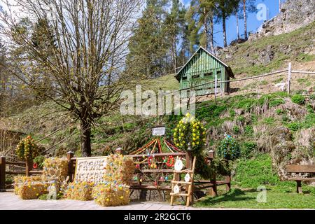 Printemps de Pâques décoré avec des oeufs de Pâques colorés à la Trubachquelle à Obertrubach en Suisse franconienne, Bavière, Allemagne Banque D'Images