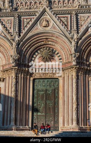 Personnes assises sur les escaliers en face de la cathédrale Santa Maria Assunta, façade, Sienne, Toscane, Italie, Europe Banque D'Images