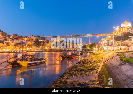 Barcos Rabelos, bateaux à vin sur le fleuve Duero en face du pont Dom Luís i et de la vieille ville historique de Porto la nuit, Portugal Banque D'Images