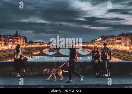 Femme avec chien, personnes appréciant l'humeur du soir, pont sur Arno, Florence, Toscane, Italie, Europe Banque D'Images