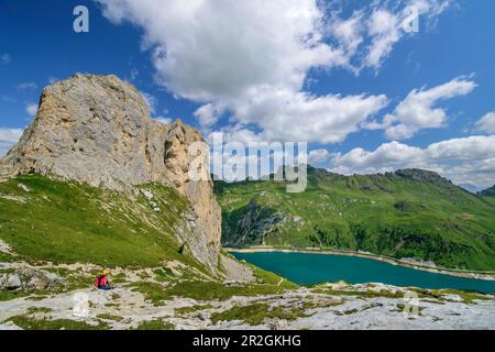 Femme alpinisme regardant sur le lac Fedaja, de la Marmolada, Dolomites, Dolomites site du patrimoine mondial de l'UNESCO, Trentin, Italie Banque D'Images