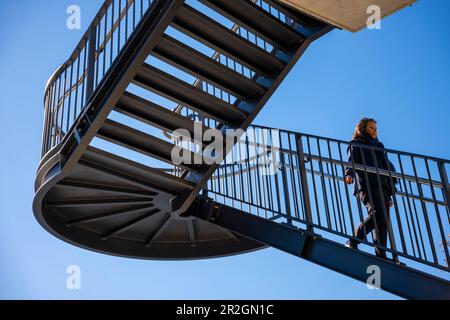 Femme marchant sur un escalier contre Blue Clear Sky avec la lumière du soleil à Lugano, Tessin, Suisse. Banque D'Images