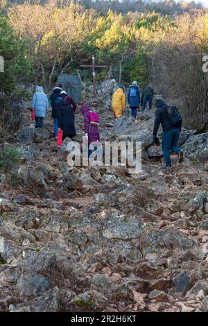 Un groupe de jeunes grimpent sur le mont Križevac à Medjugorje le matin froid de février. Banque D'Images