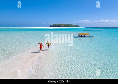Homme et femme gai ayant plaisir à se traquer les uns les autres sur une plage tropicale, vue aérienne, Zanzibar, Tanzanie, Afrique de l'est, Afrique Banque D'Images