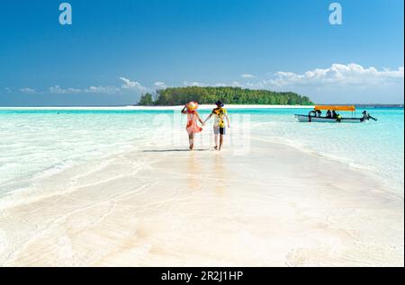Homme et femme amoureux tenant les mains marchant sur la côte de sable vide entouré par l'océan Indien, Zanzibar, Tanzanie, Afrique de l'est, Afrique Banque D'Images