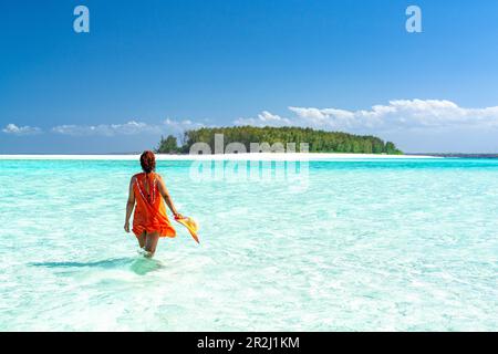 Femme admirant une île exotique se tenant dans la mer bleu cristal, Zanzibar, Tanzanie, Afrique de l'est, Afrique Banque D'Images