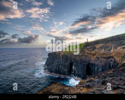 Falaise au-dessus de l'océan, avec une arche naturelle et un petit phare, Farolim dos Fenais da Ajuda, île de Sao Miguel, îles des Açores, Portugal Banque D'Images