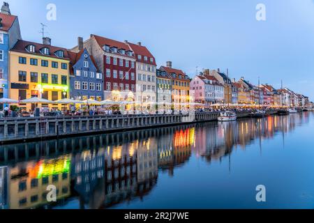 Maisons colorées, restaurants et navires historiques au canal de Nyhavn et port au crépuscule, Copenhague, Danemark, Europe Banque D'Images