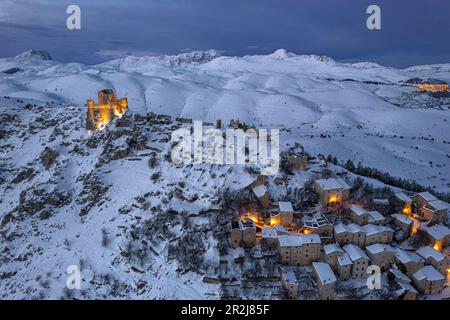 En hiver, vue sur le village médiéval éclairé de Rocca Calascio, couvert de neige, avec le château au crépuscule, Rocca Calascio Banque D'Images