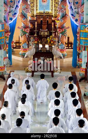 Temple CAO Dai, disciples Caodaistes assis pendant la cérémonie, Tan Chau, Vietnam, Indochine, Asie du Sud-est, Asie Banque D'Images