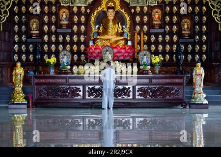 Femme priant à l'autel principal, temple bouddhiste Phat Quang, Siddhartha Gautama (le Bouddha Shakyamuni), Chau Doc, Vietnam, Indochine, Asie du Sud-est Banque D'Images