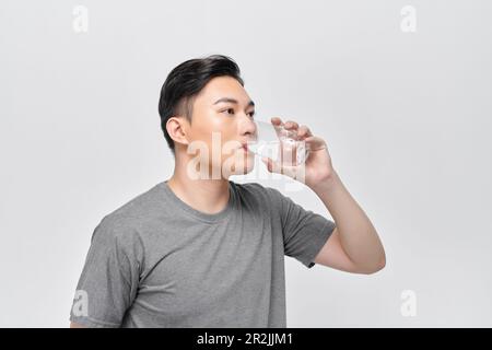 Un homme boit de l'eau dans un verre Banque D'Images