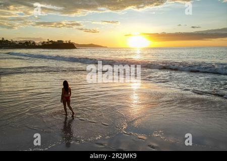 Vue aérienne d'une femme marchant sur Flamingo Beach au coucher du soleil, Playa Flamingo, Guanacaste, Costa Rica, Amérique centrale Banque D'Images