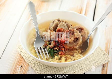 Bakso ou Meatball avec Noodle jaune, servi avec de la sauce épicée Sambal. Sur le bol blanc, gros plan Banque D'Images