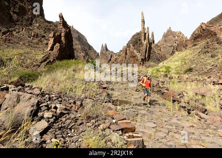 Garçon, adolescent, randonneur sur un sentier de randonnée dans les canyons près de Cha de Morte, avec des formations rocheuses spectaculaires autour de lui, île de Santo Antao, Cabo verde Banque D'Images