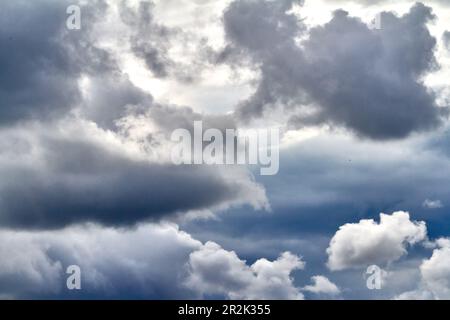 Les nuages gris pluvieux couvrent le ciel bleu Banque D'Images