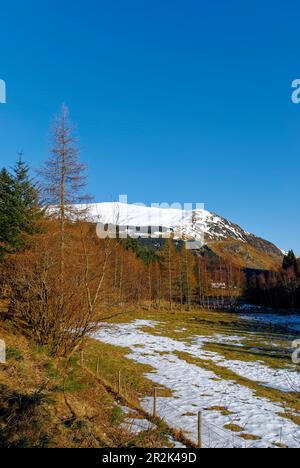 En regardant sur le chemin de Corrie Fee vers Glendoll Lodge et Cairn Broadland, lors d'une journée hivernale en février, avec de la neige sur les collines. Banque D'Images