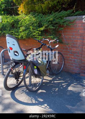 Deux vélos dans Un support de vélo près D'Un mur de briques Banque D'Images