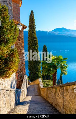 Escalier de l'église Santa Maria del Sasso contre ciel bleu clair et montagne sur le lac de Lugano en une journée ensoleillée à Morcote, Tessin en Suisse. Banque D'Images