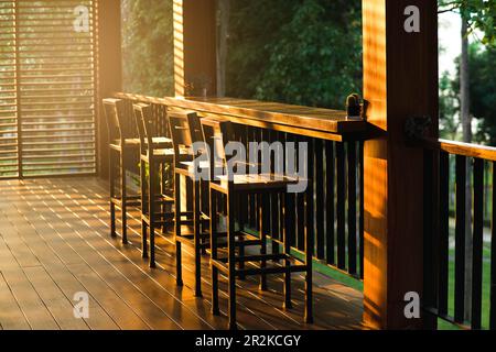 Des tabourets de bar en bois vintage sur la terrasse du café par temps ensoleillé. Banque D'Images