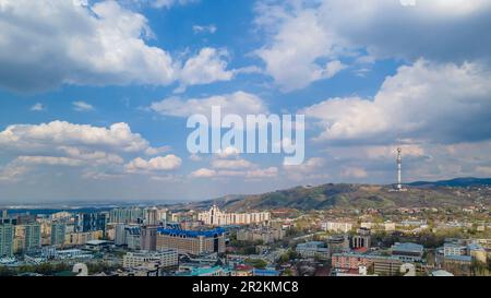 Almaty, Kazakhstan - 12 avril 2022 : bâtiments de plusieurs étages de la ville et tour de télévision sur la montagne. Point de vue du drone Banque D'Images