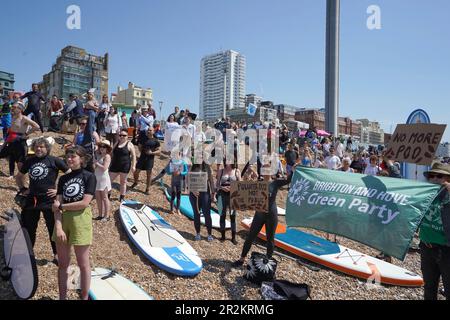 Des manifestants sur la plage tandis que Surfers contre les eaux usées tiennent une manifestation de paddle-out dans tout le Royaume-Uni à Brighton West Pier dans East Sussex, demandant la fin des rejets d'eaux usées dans les eaux de baignade du Royaume-Uni d'ici 2030. Date de la photo: Samedi 20 mai 2023. Banque D'Images