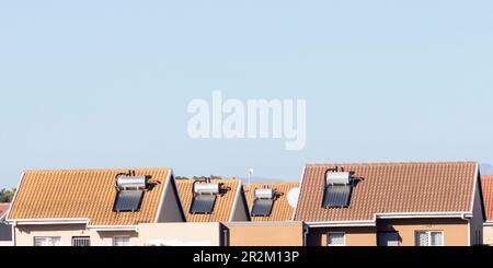 Geysers solaires d'eau chaude sur le toit sur des maisons dans un logement à faible revenu. Puissance alternative et ressources naturelles durables Banque D'Images