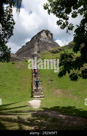 San Ignacio, Belize - 24 août 2019 : les visiteurs grimpent les escaliers escarpés jusqu'à la ruine maya ensoleillée « El Castillo » sur le site archéologique de Xunantunich Banque D'Images