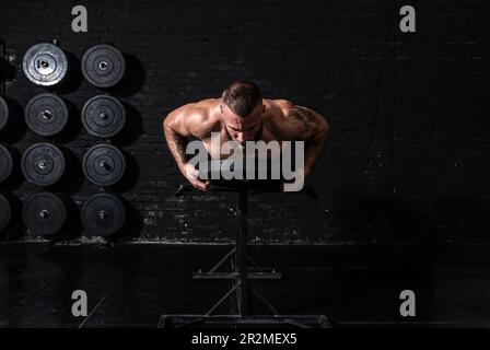 Jeune actif forte Sweaty focalisé ajustement musclé homme avec de grands muscles tenant le poids lourd kettlebell haltères barbell pour balancer entraînement crossfit dur Banque D'Images